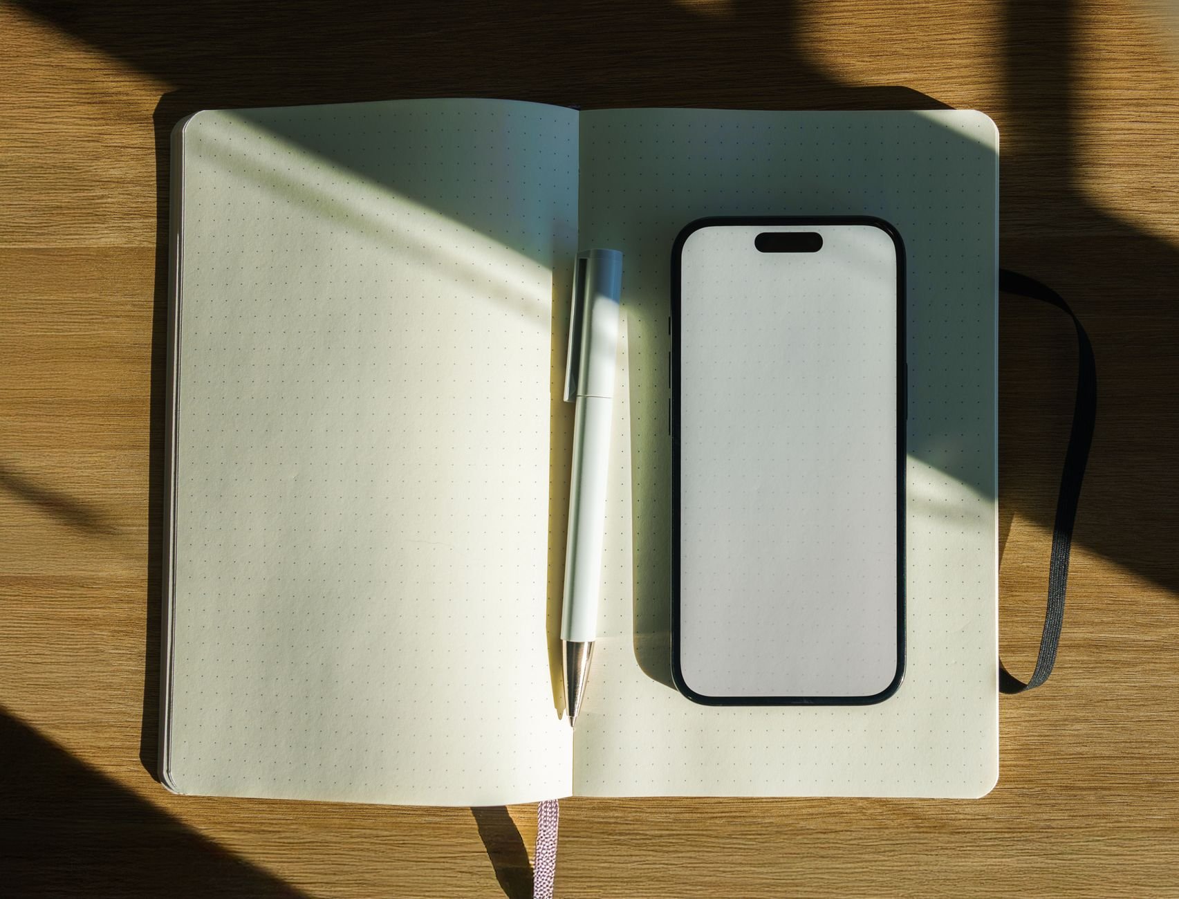 A sunlit workspace with an open notebook and pen — the kind of organised desk Flowkitt helps you achieve